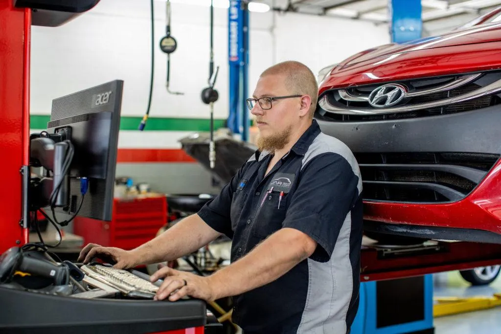 Technician on the computer in auto shop