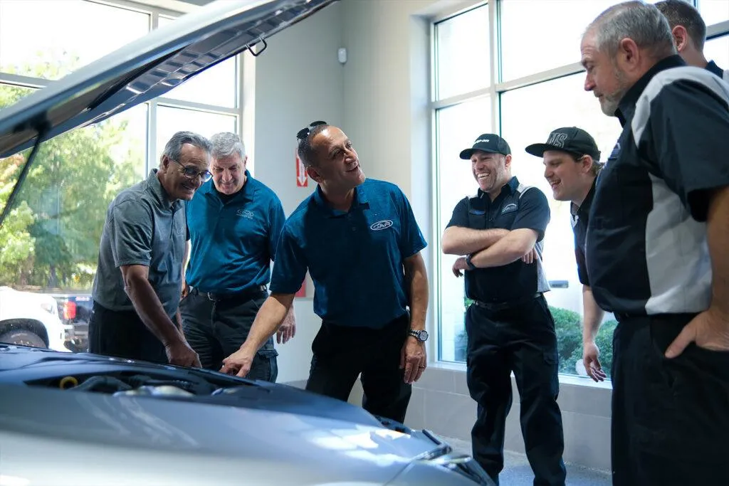 The Japanese Auto Repair Team Consulting about a Car Engine