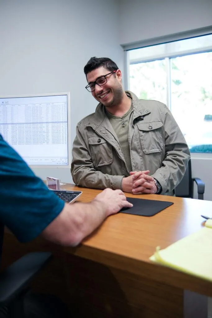 Satisfied Customer Checking Out At The Desk