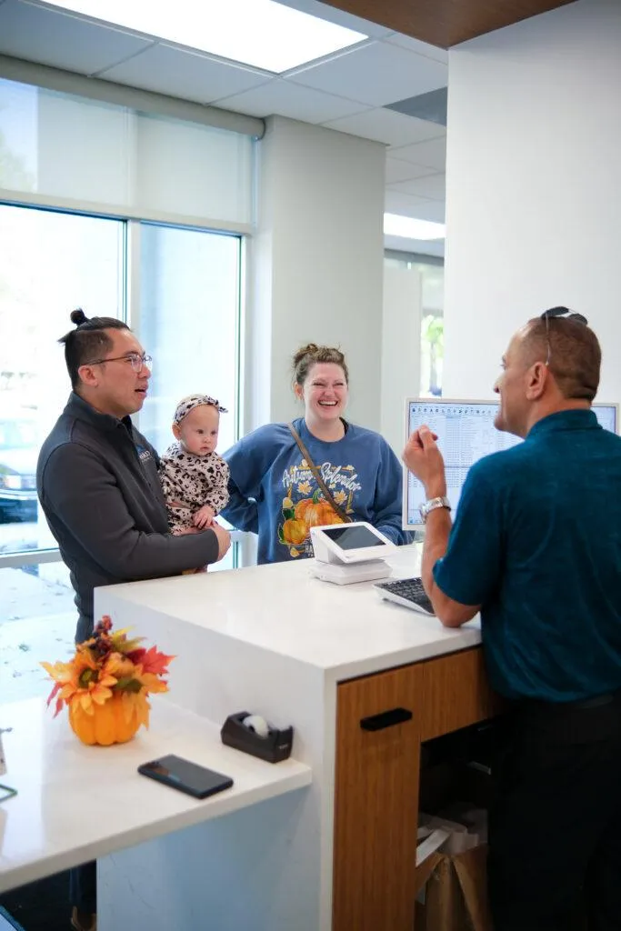 Customers Laughing with Car Shop Owner