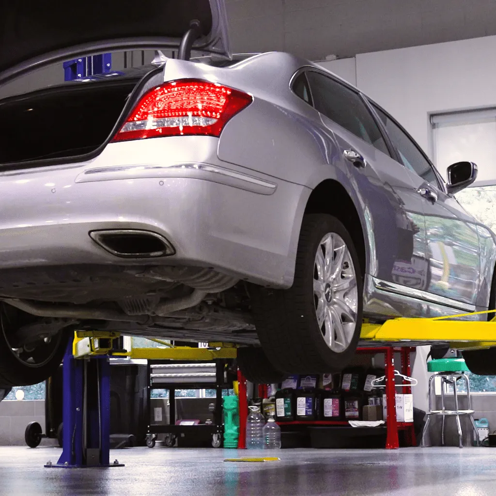 gray car lifted off of the ground with trunk open
