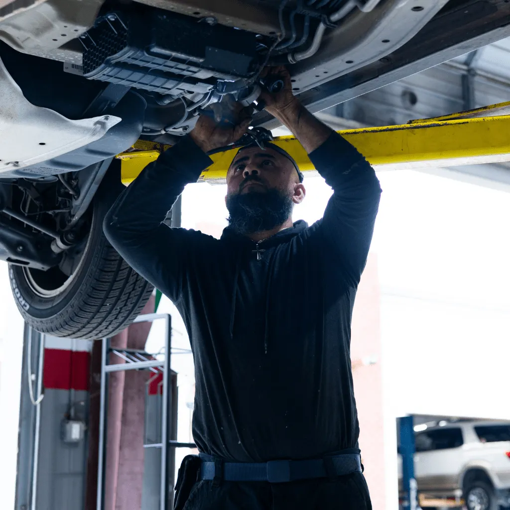 mechanic actively working on lifted vehicle