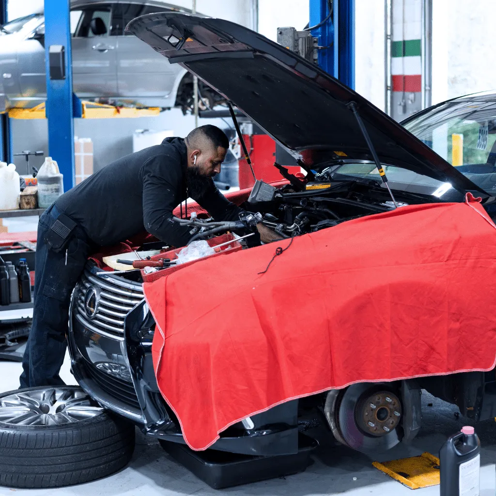 mechanic working under the hood of lexus